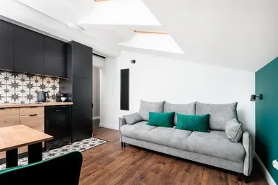 a living room with a couch and a table at The Vitrail Apartments - by Upstairs in Kraków