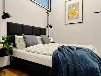 a bedroom with a bed with a black headboard at Beautiful apartments Kazimierz District, Kraków Old Town City Center in Kraków