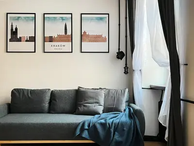 a living room with a couch and four pictures on the wall at Beautiful apartments Kazimierz District, Kraków Old Town City Center in Kraków