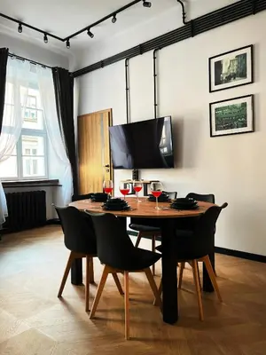 a dining room with a wooden table and chairs at Beautiful apartments Kazimierz District, Kraków Old Town City Center in Kraków