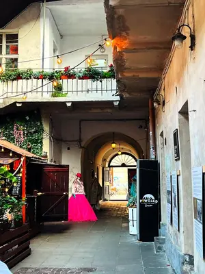 a woman in a pink dress walking down an alley at Beautiful apartments Kazimierz District, Kraków Old Town City Center in Kraków