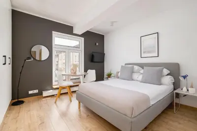 a bedroom with a bed and a table and a mirror at Studio apartment - Kalwaryjska 34 street in Kraków