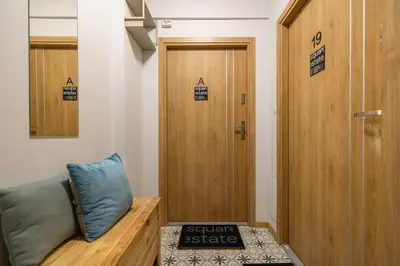 a locker room with a couch and a wooden door at Studio apartment - Kalwaryjska 34 street in Kraków