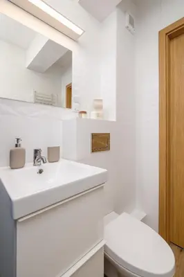 a white bathroom with a toilet and a sink at Studio apartment - Kalwaryjska 34 street in Kraków