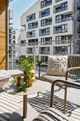 a balcony with a couch and a table and a building at City Dreams Apartment in Kraków