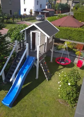 a play house with a slide and a swing at Lawendowy Zakątek in Wadowice