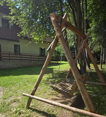 a wooden swing hanging from a tree in a yard at Fundacja DPT Zawoja Dom Pracy Twórczej PAU in Zawoja