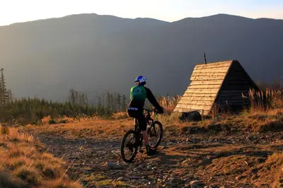 a man riding a bike down a dirt road at Fundacja DPT Zawoja Dom Pracy Twórczej PAU in Zawoja