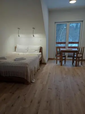 a bedroom with a bed and a table and chairs at Fundacja DPT Zawoja Dom Pracy Twórczej PAU in Zawoja
