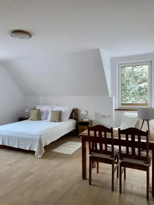 a bedroom with a bed and a chair and a window at Fundacja DPT Zawoja Dom Pracy Twórczej PAU in Zawoja