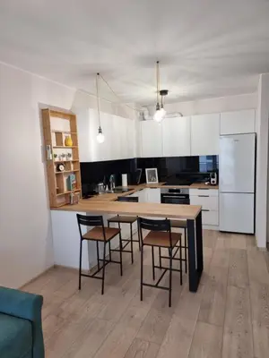a kitchen with a table and chairs and a refrigerator at K Everhome in Kraków