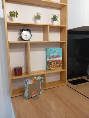 a book shelf with a clock and a box at K Everhome in Kraków