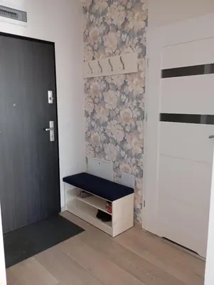 a room with a door and a bench next to a wall at K Everhome in Kraków