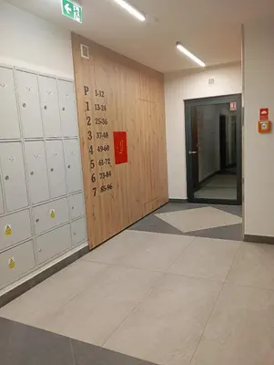 a hallway with lockers and a door in a building at K Everhome in Kraków