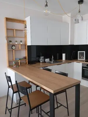 a kitchen with a wooden table and chairs at K Everhome in Kraków