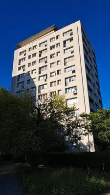 a tall white building with trees in front of it at Przy Parku Wyspiańskiego in Kraków