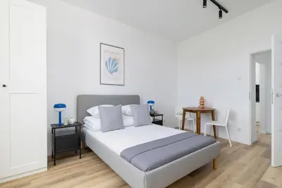 a white bedroom with a bed and a table at Studio apartment - 65 Długa Street in Kraków