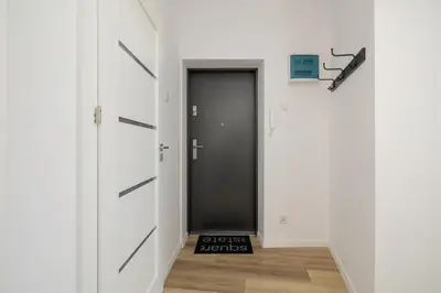 a hallway with a black door and a black door at Studio apartment - 65 Długa Street in Kraków