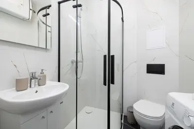a bathroom with a shower and a sink and a toilet at Studio apartment - 65 Długa Street in Kraków