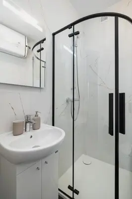 a white bathroom with a sink and a shower at Studio apartment - 65 Długa Street in Kraków