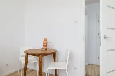 a table and chairs in a room with white walls at Studio apartment - 65 Długa Street in Kraków