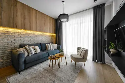 a living room with a blue couch and a brick wall at Velvet Dreams Apartments 46 in Kraków