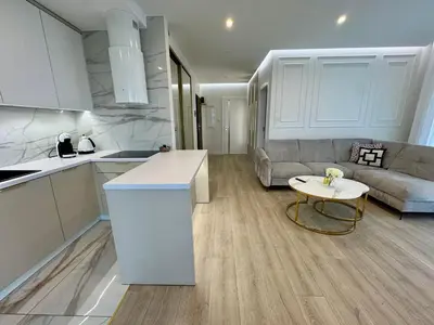 a kitchen and living room with a couch and a table at Apartament Deluxe Wiślane Tarasy 2 I Parking in Kraków