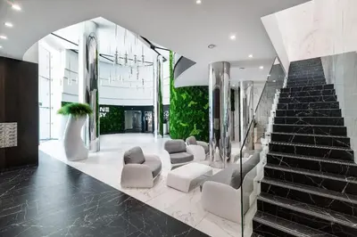 a lobby with white chairs and a staircase at Apartament Deluxe Wiślane Tarasy 2 I Parking in Kraków