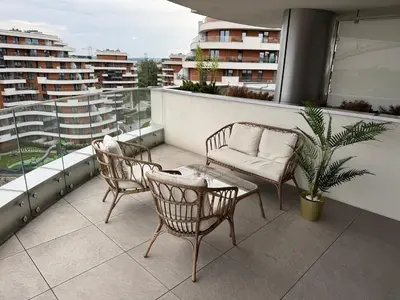 a balcony with two chairs and a couch and a table at Apartament Deluxe Wiślane Tarasy 2 I Parking in Kraków