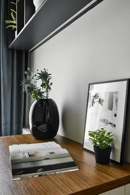 a table with a picture and a vase with plants on it at Velvet Dreams Apartments 49 in Kraków