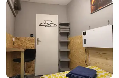 a room with a bed and a desk and a shelf at Pokój kapsułowy 7 in Kraków