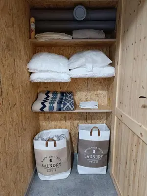a shelf with towels and bags in a room at Pokój kapsułowy 7 in Kraków