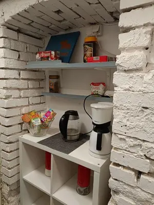 a kitchen shelf with a coffee maker on it at Pokój kapsułowy 7 in Kraków