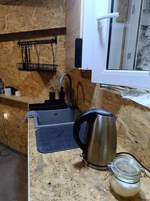 a tea kettle on a counter next to a sink at Pokój kapsułowy 7 in Kraków