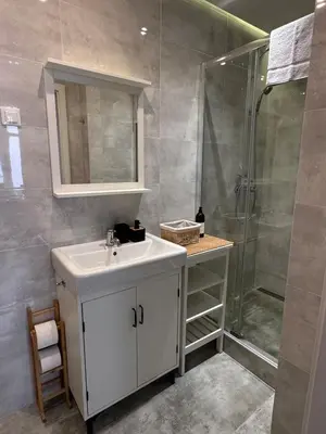 a bathroom with a white sink and a shower at Topolova Apartament - Stare Miasto, 10 min od Rynku in Kraków