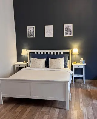 a bed with blue and white pillows and a lamp at Topolova Apartament - Stare Miasto, 10 min od Rynku in Kraków