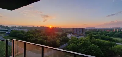 a view of the sunset from a balcony of a building at Sunrise Apartament in Kraków