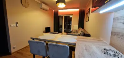 a dining room with a table and some chairs at Sunrise Apartament in Kraków