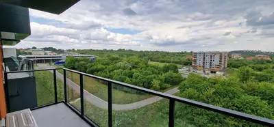 a balcony with a view of a street and trees at Sunrise Apartament in Kraków