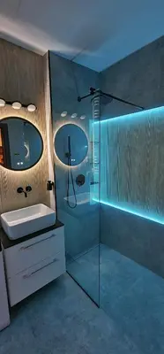 a bathroom with a glass shower and a sink at Sunrise Apartament in Kraków