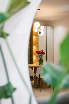 a table and chairs with a vase of red roses at Apartment Grodzka 27 in Kraków