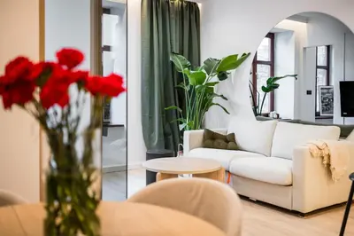 a living room with a white couch and red flowers in a vase at Apartment Grodzka 27 in Kraków