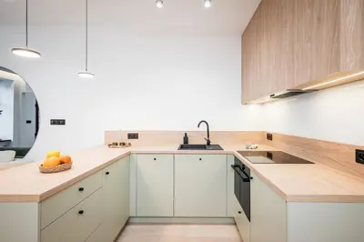 a kitchen with white cabinets and a sink at Apartment Grodzka 27 in Kraków