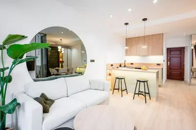 a living room with a white couch and a kitchen at Apartment Grodzka 27 in Kraków