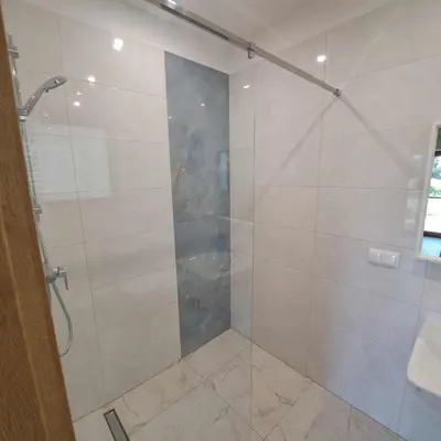 a bathroom with a shower with a glass door at Niwy8Rooms in Oświęcim