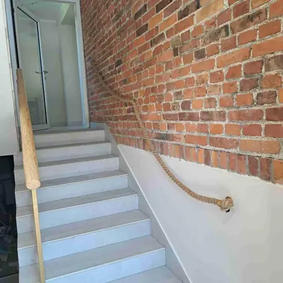 a brick wall with a staircase next to a brick stair leash at Niwy8Rooms in Oświęcim
