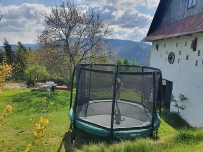 a person standing on a trampoline in the grass at Agroturystyka Z Głową w Chmurach - Zawoja in Zawoja