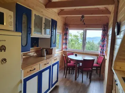 a kitchen and dining room with a table and chairs at Agroturystyka Z Głową w Chmurach - Zawoja in Zawoja