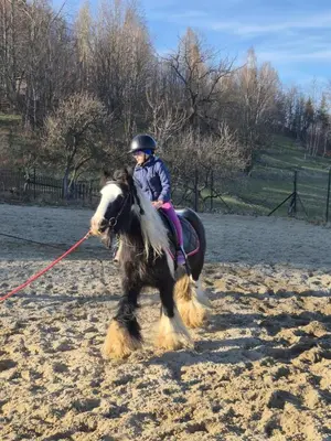 a little girl riding a horse with a helmet on at Agroturystyka Z Głową w Chmurach - Zawoja in Zawoja
