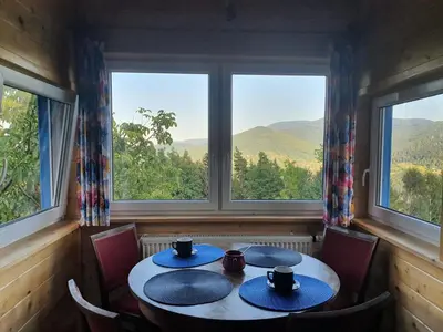 a table in a room with a view of the mountains at Agroturystyka Z Głową w Chmurach - Zawoja in Zawoja